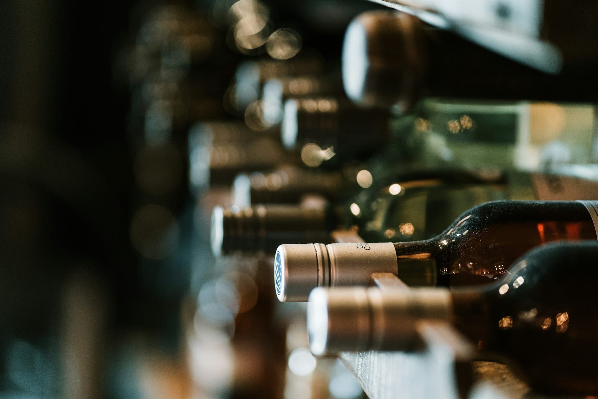 Wine bottles resting in a cellar rack